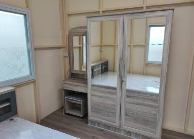 Spacious bedroom with large mirrored wardrobe and built-in dressing table