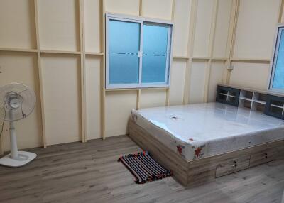 Minimalist bedroom with large window and laminate flooring