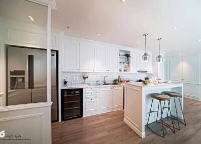 Modern kitchen with white cabinetry, stainless steel appliances, and a center island