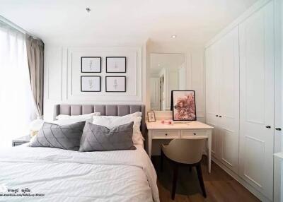 Cozy bedroom interior with neatly made bed, wall art, and a vanity desk