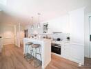 Modern white kitchen with center island and stainless steel appliances