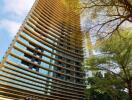 Modern high-rise residential building with lush green trees