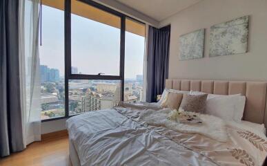 Modern bedroom with large windows and city view