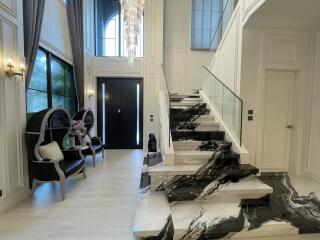 Elegant interior foyer with marble staircase and chandelier