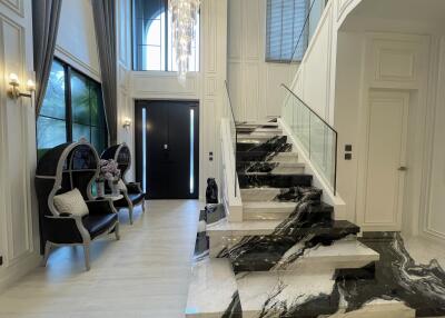 Elegant interior foyer with marble staircase and chandelier