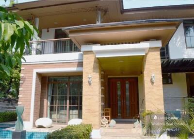 Elegant home entrance with a welcoming porch and swimming pool