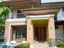 Elegant home entrance with a welcoming porch and swimming pool