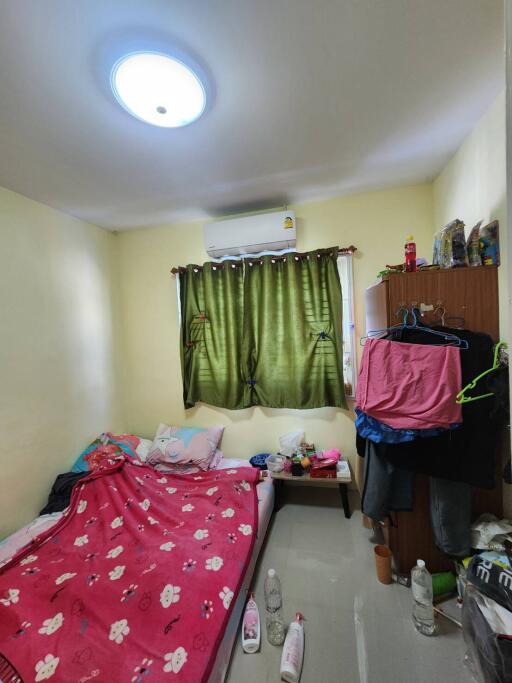 Compact bedroom with personal items and air conditioning