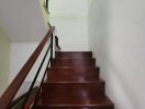 Polished wooden staircase inside a home with white walls