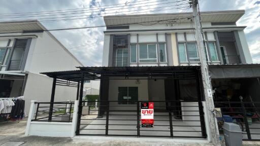 Modern two-story residential building exterior with for sale sign