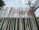 Metal fence with the word 'PENO' in red at a property entrance