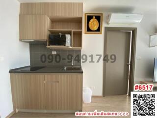 Compact modern kitchen with wooden cabinets and microwave