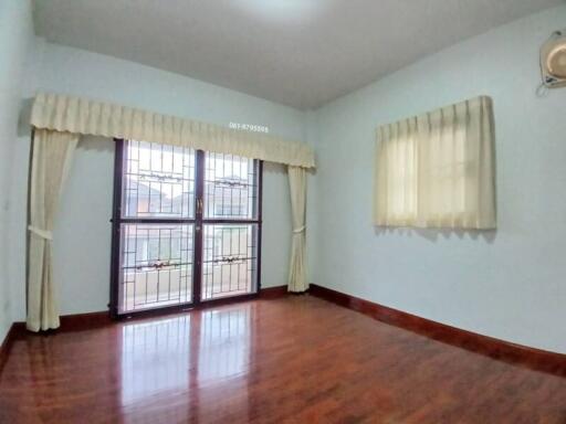 Spacious bedroom with large windows and hardwood floors