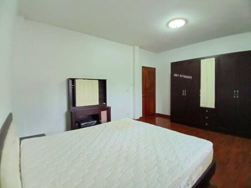 Spacious bedroom with double bed and wooden furniture