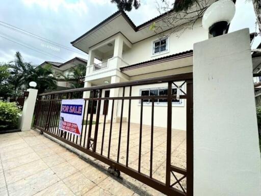 Two-story house facade with for sale sign and gated entrance