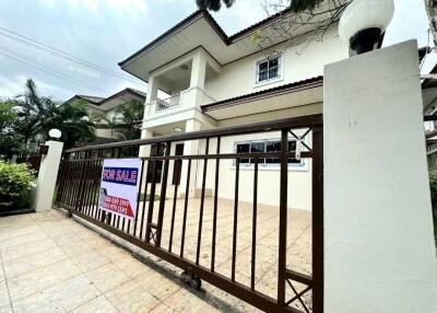 Two-story house facade with for sale sign and gated entrance