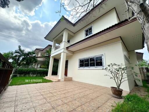 Spacious two-story house with a large tiled patio and green surroundings