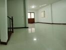 Spacious and well-lit living room with shiny tiled floors