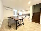 Spacious open plan living room with dining area, modern kitchen, and staircase