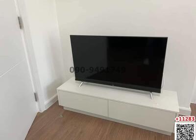 Modern television on a sleek white TV stand in a clean living room setting