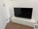 Modern television on a sleek white TV stand in a clean living room setting