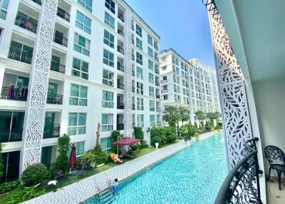 View from the balcony overlooking a communal swimming pool and apartment complex