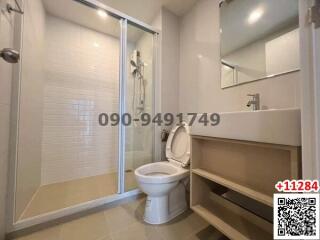 Modern clean bathroom interior with glass shower and wooden shelf