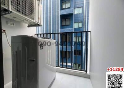 Compact balcony with blue building view and outdoor unit of an air conditioner
