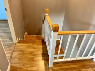 Modern hallway with wooden floors and white bannister