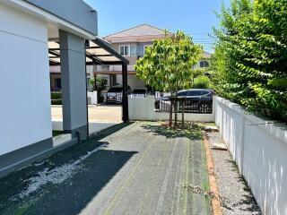 Paved driveway leading to a modern home with carport and enclosed gate