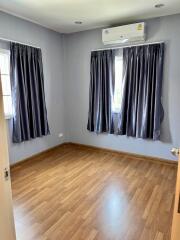 Empty bedroom with hardwood floors and curtains