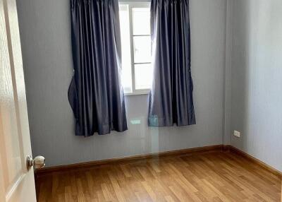Empty bedroom with wooden floor and grey walls