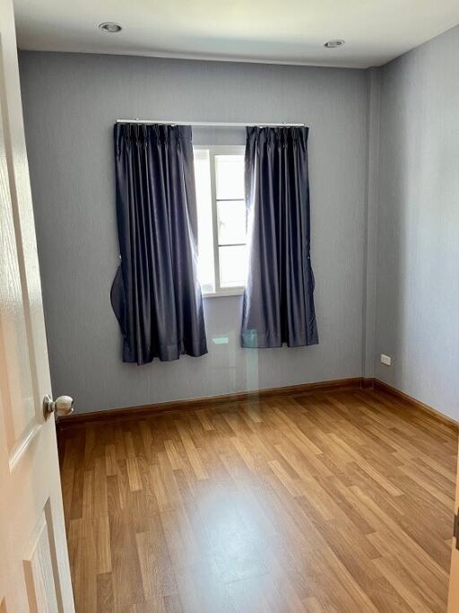Empty bedroom with wooden floor and grey walls
