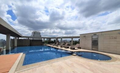 Rooftop swimming pool with lounge chairs and city view