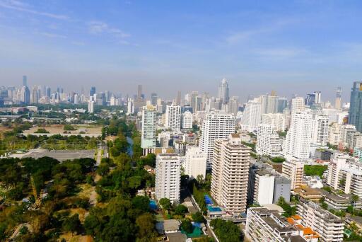 Panoramic view of a bustling city with skyscrapers and green spaces