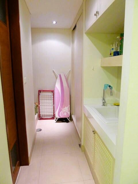 Compact hallway with laundry facilities and built-in cabinets