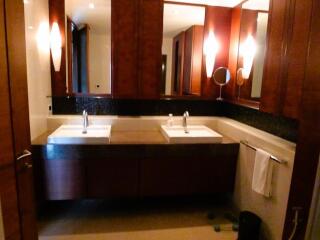 Modern bathroom with dual sinks and wooden cabinets