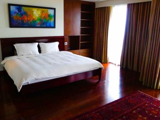 Spacious bedroom with hardwood floors and modern decor