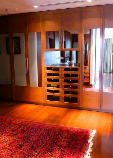 Elegant living room with hardwood flooring, wooden cabinetry, and a red area rug