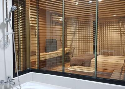 Modern bathroom with shower and a visible sauna through glass doors