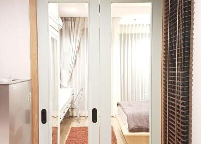 View into a cozy bedroom with a large bed and warm lighting through French doors