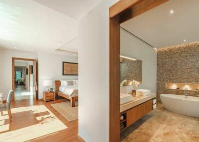 Luxurious bathroom connected to bedroom with a freestanding tub, dual vanities, and modern design