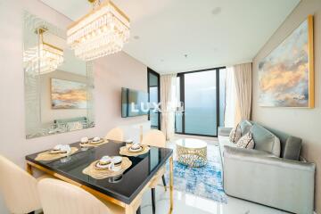 Elegant living room with dining area, modern furniture, and a stunning sea view