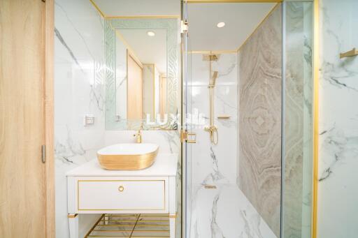 Modern bathroom interior with marble tiles and gold accents
