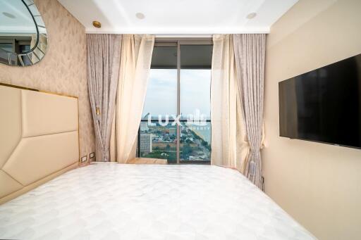 Spacious bedroom with large windows and city view