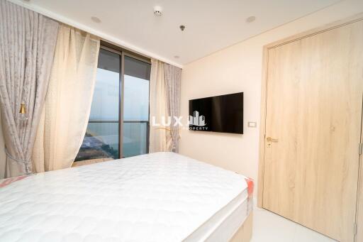 Spacious bedroom with a large window and waterfront view