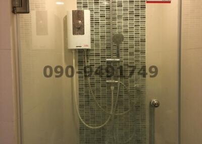 Modern glass-enclosed shower with mosaic tile wall