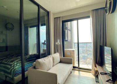 Cozy bedroom with a comfortable sofa, glass partition, and city views