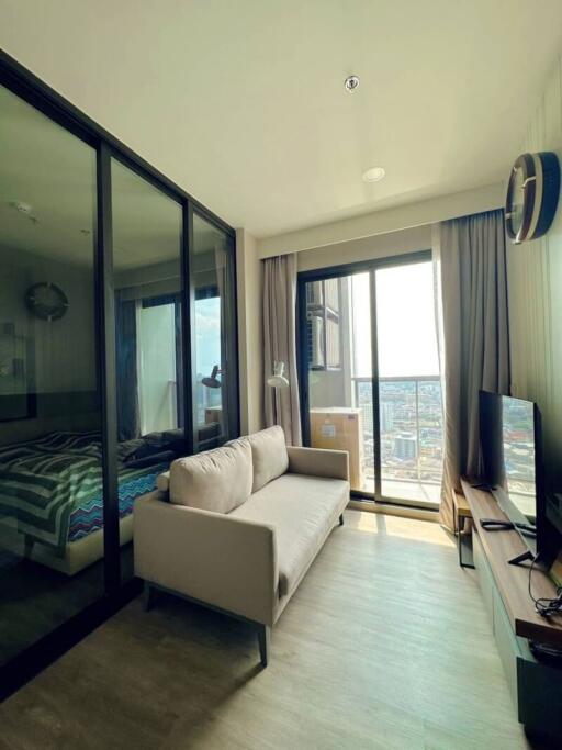 Cozy bedroom with a comfortable sofa, glass partition, and city views