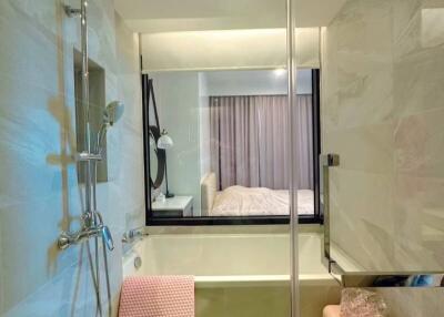 Modern bathroom with glass shower cabin overlooking bedroom